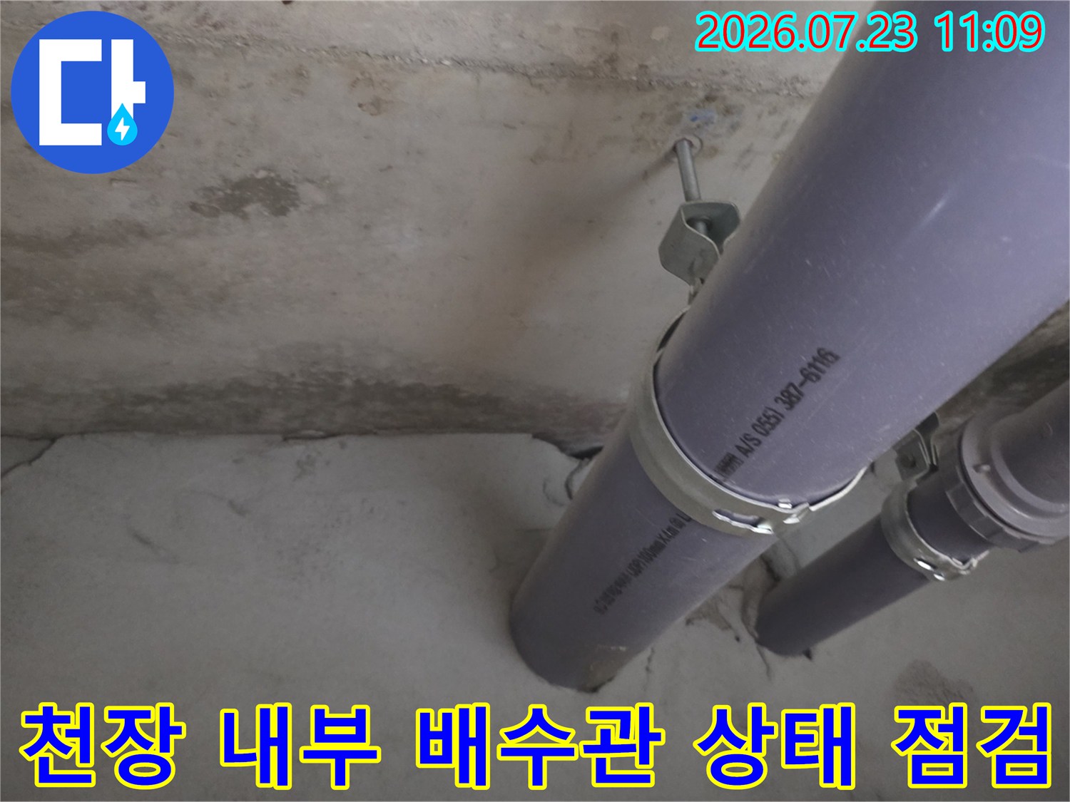 아파트-천장-내부에-설치된-회색-플라스틱-배수관과-고정-클램프-모습