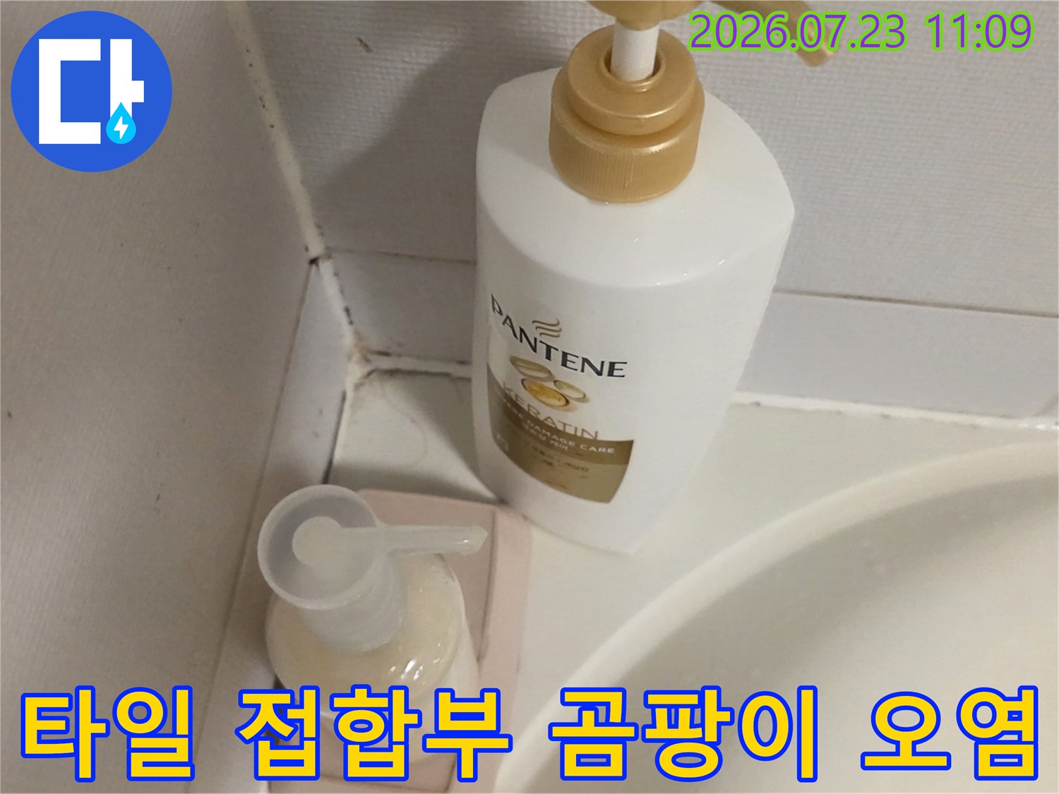 화장실 세면대 주변 타일 모서리에 형성된 어두운 색상의 오염 구역