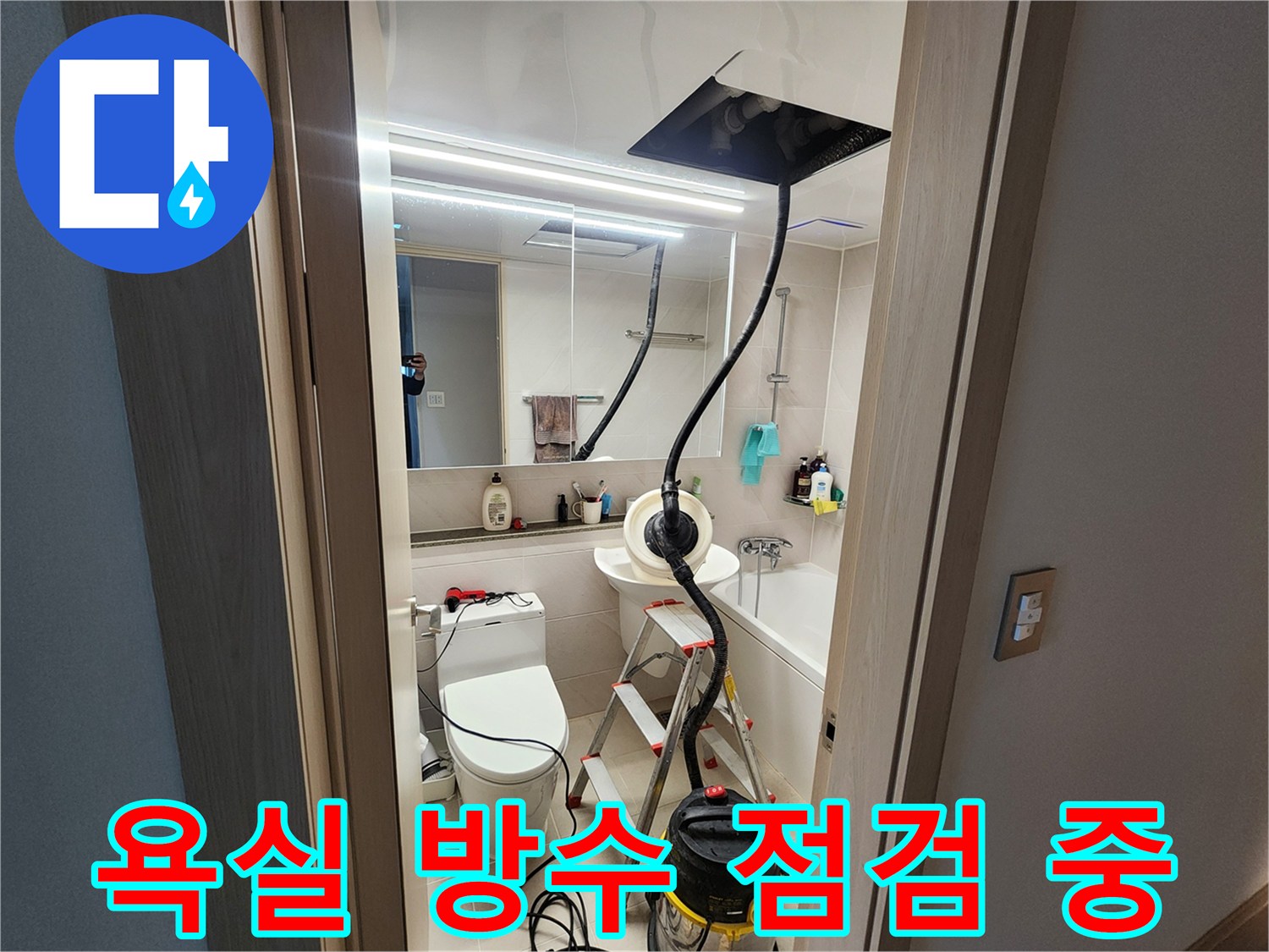 사다리와 청소 장비가 놓인 화장실 내부의 작업 준비 상태