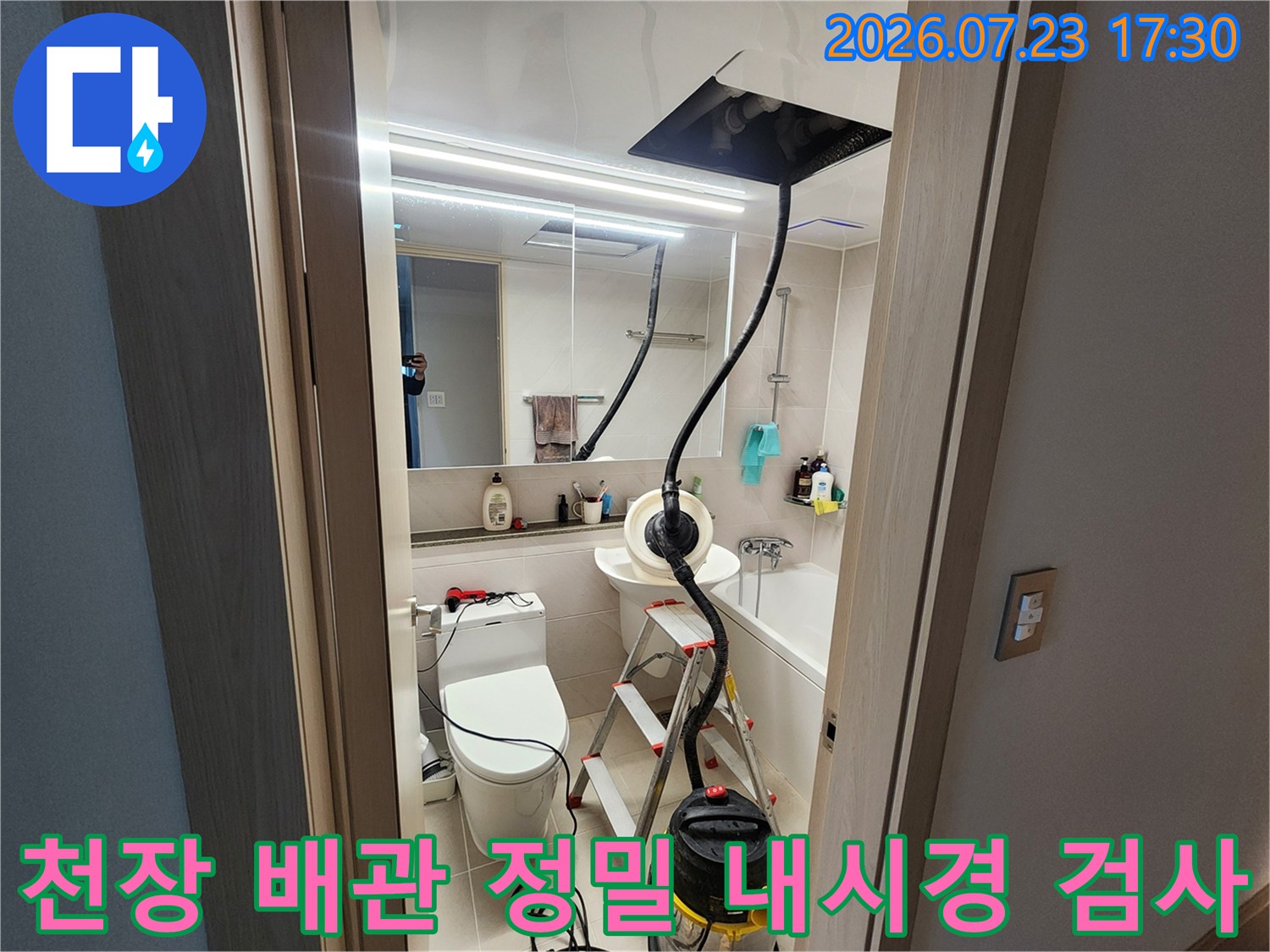 욕실 천장 점검구를 통해 투입된 내시경 호스와 바닥의 작업용 사다리-청소 장비
