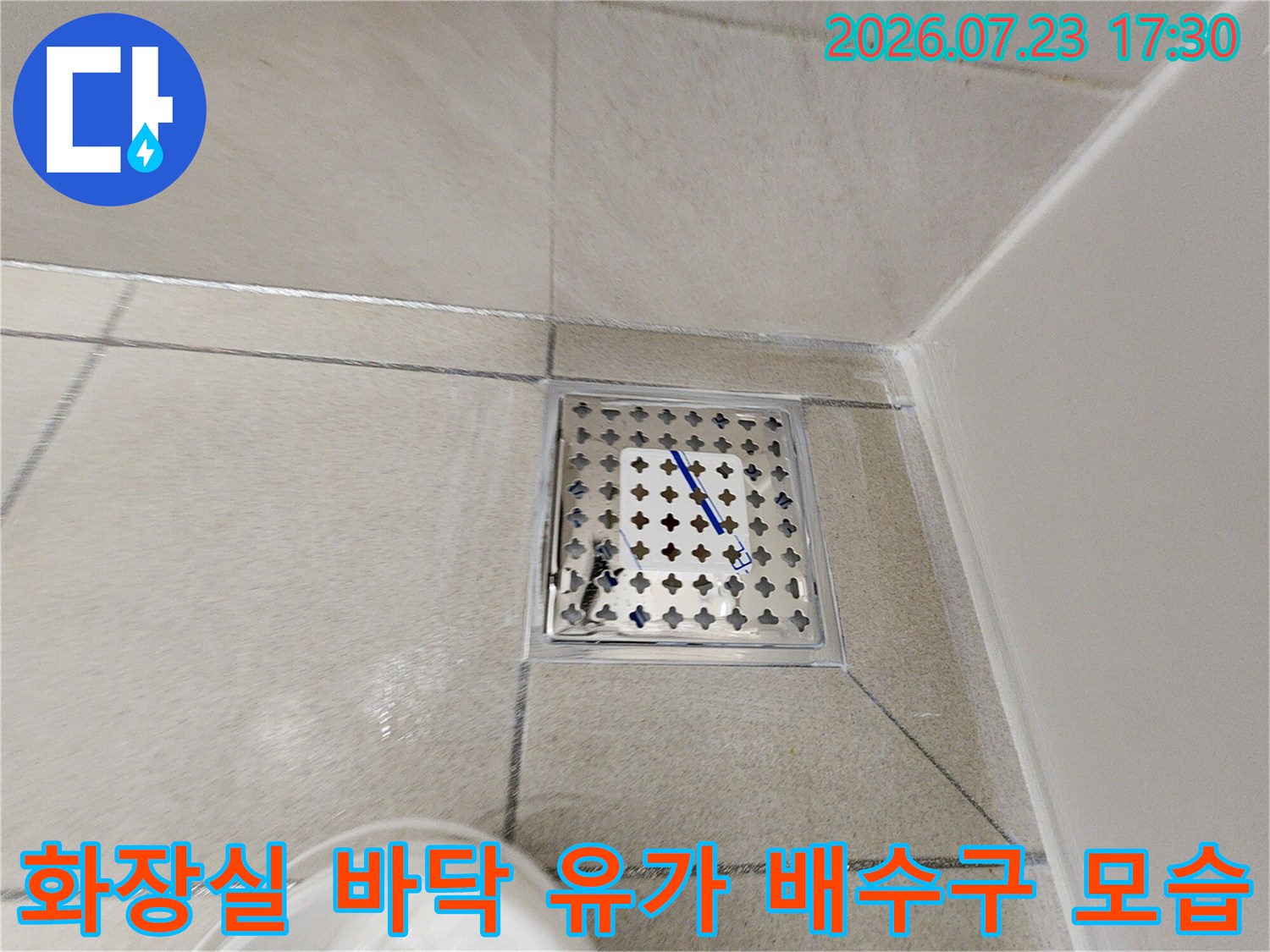 화장실 바닥에 설치된 격자 모양의 스텐레스 재질 유가-배수구 사진