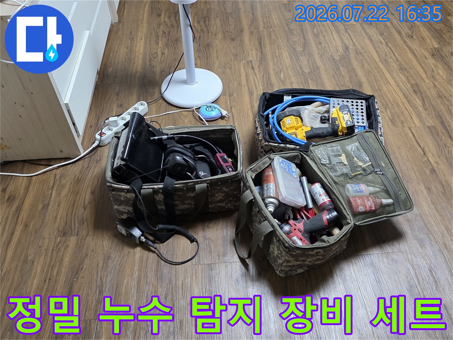 거실 바닥에 펼쳐진-누수 진단용 청음기와 전동공구-및 각종 측정 장비들