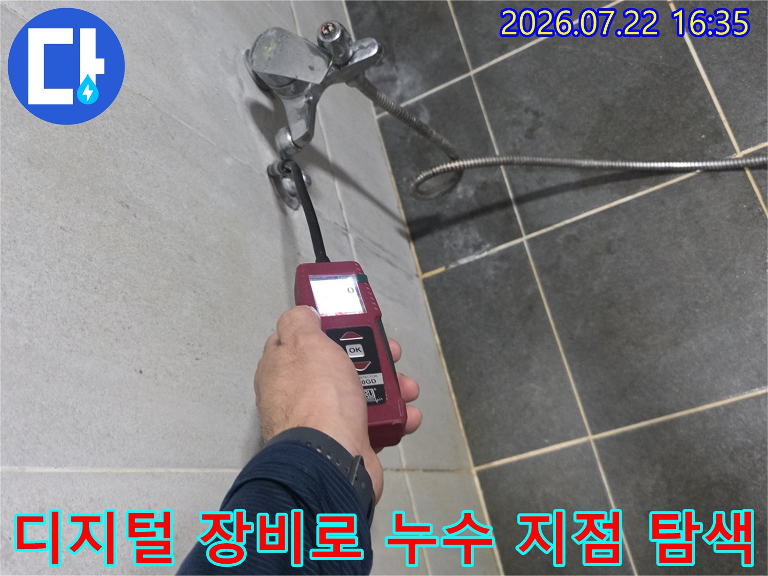 성북구 정릉동 현장에서-엔지니어가-빨간색 디지털 탐지기로-벽면 배관의-누수 지점을-정밀하게-측정하고 있는 모습