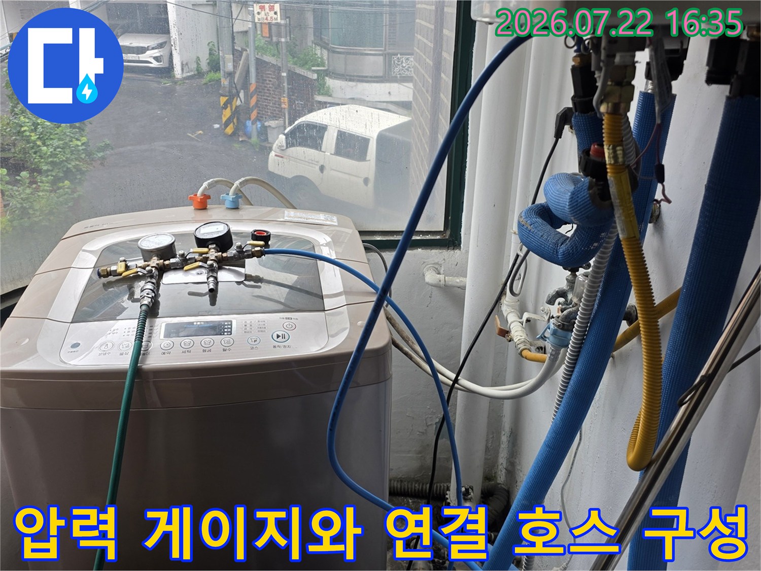 세탁실 공간에 설치되어 배관 압력을 측정하고 있는 누수 탐지 장비-파란색 라인 연결 모습