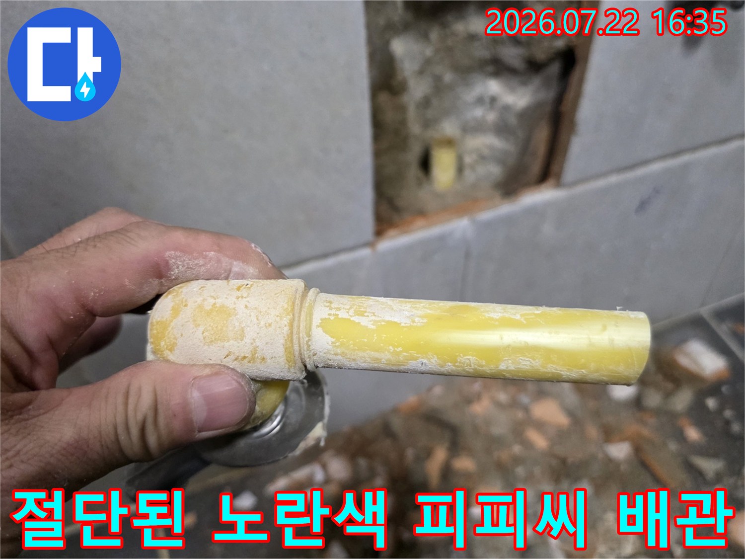 손으로 잡고 있는-파손되어 절단된-노란색 수도 배관 사진
