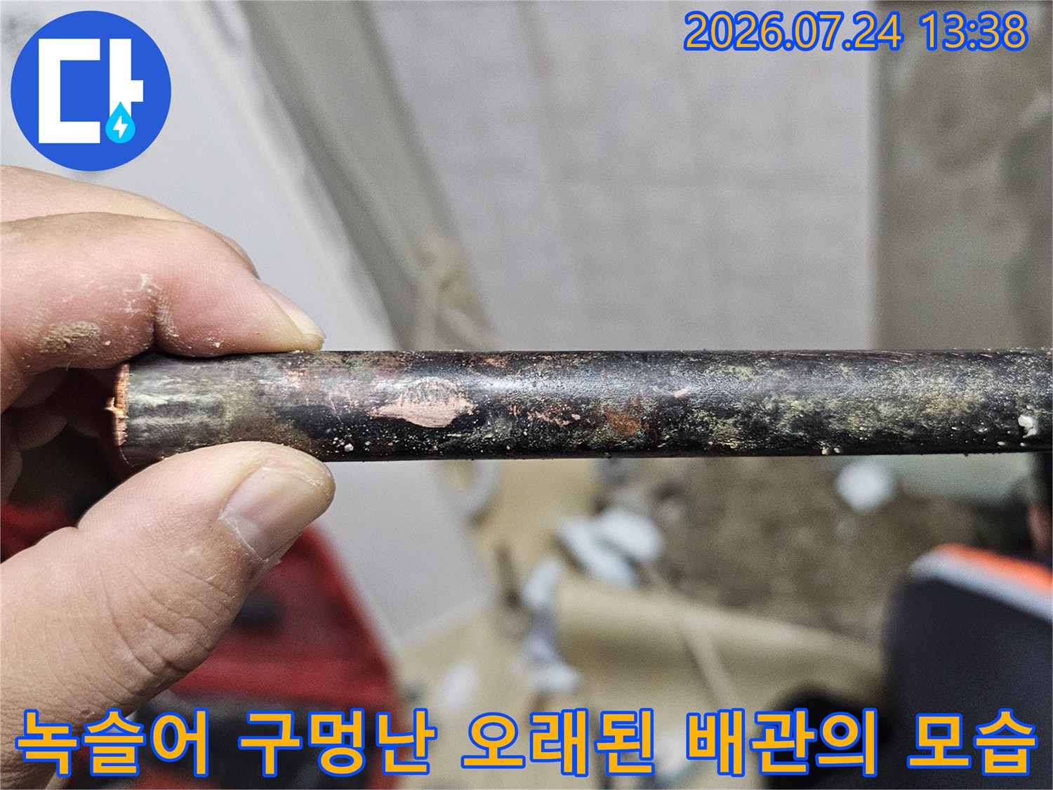 심한 부식으로 인해 표면이 울퉁불퉁하고 변색된 금속제 누수 배관