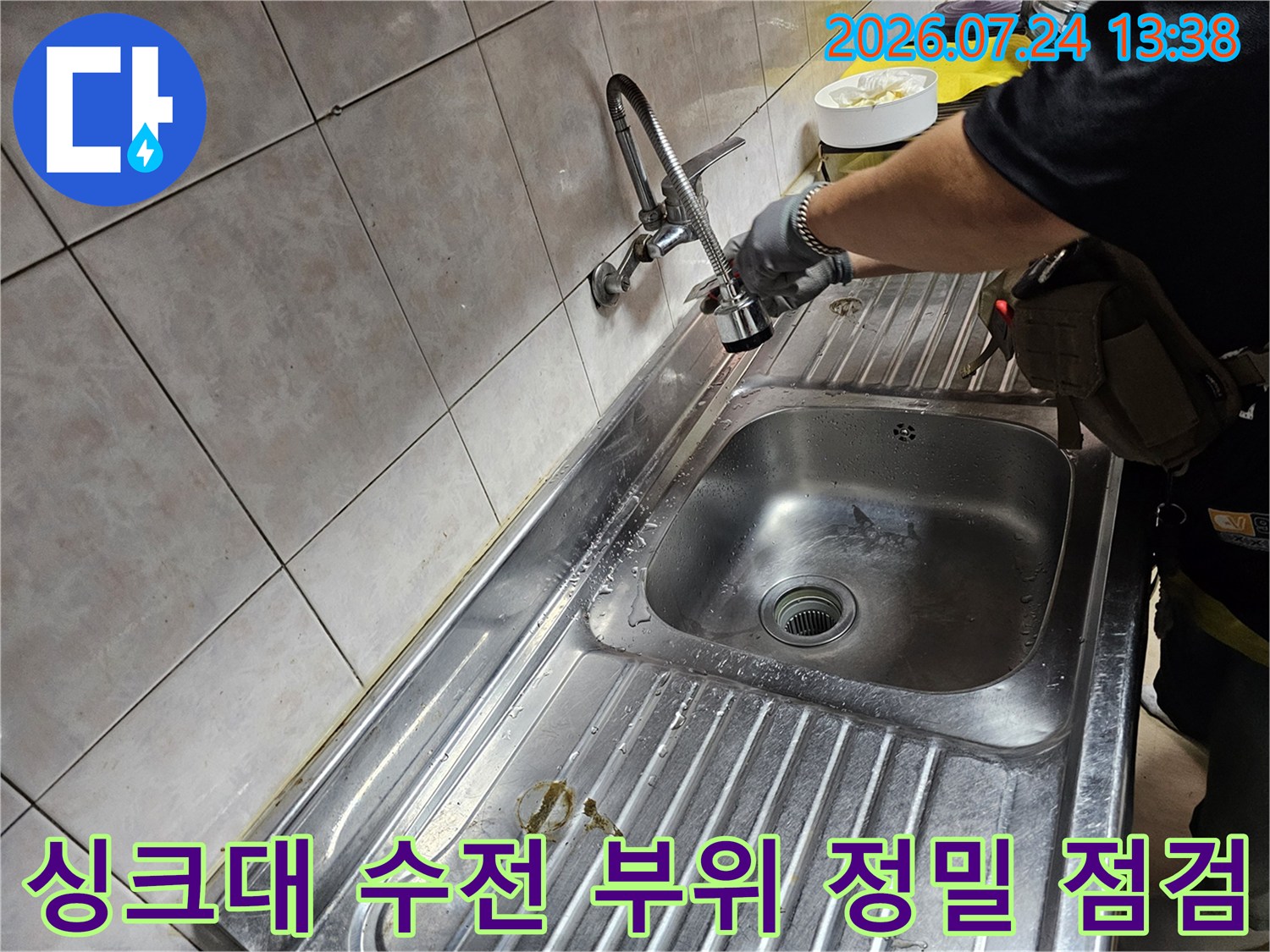 작업자가 주방 싱크대의 수도꼭지 하단 연결 부위를 손으로 만지며 누수를 체크하는 모습
