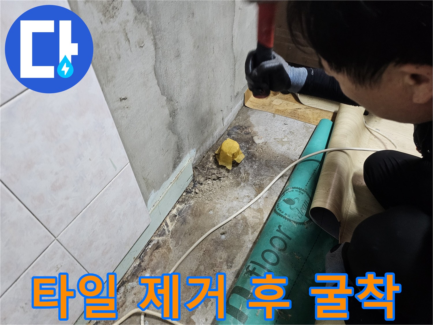 제거된 타일 조각과 함께 바닥 시멘트층이 드러난 현장 사진입니다.