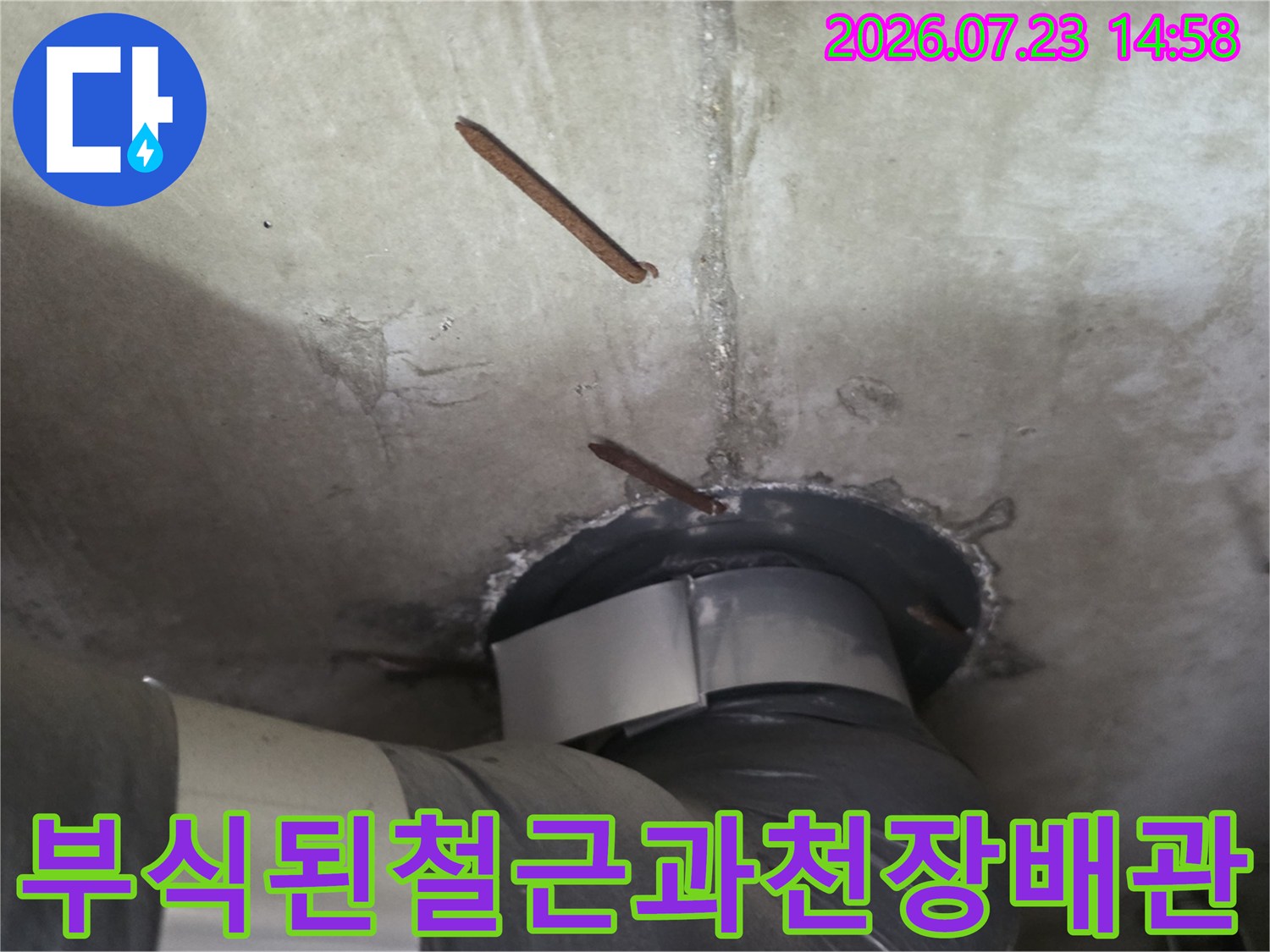 콘크리트 천장에서 부식되어 돌출된 철근과 연결된 배관 모습