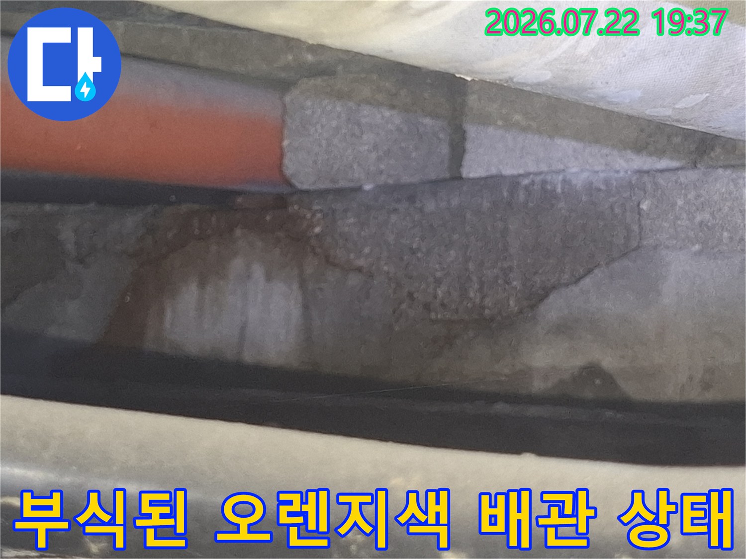 천장 내부-부식이 진행되어 표면이 거칠어진 오렌지색 배관 모습