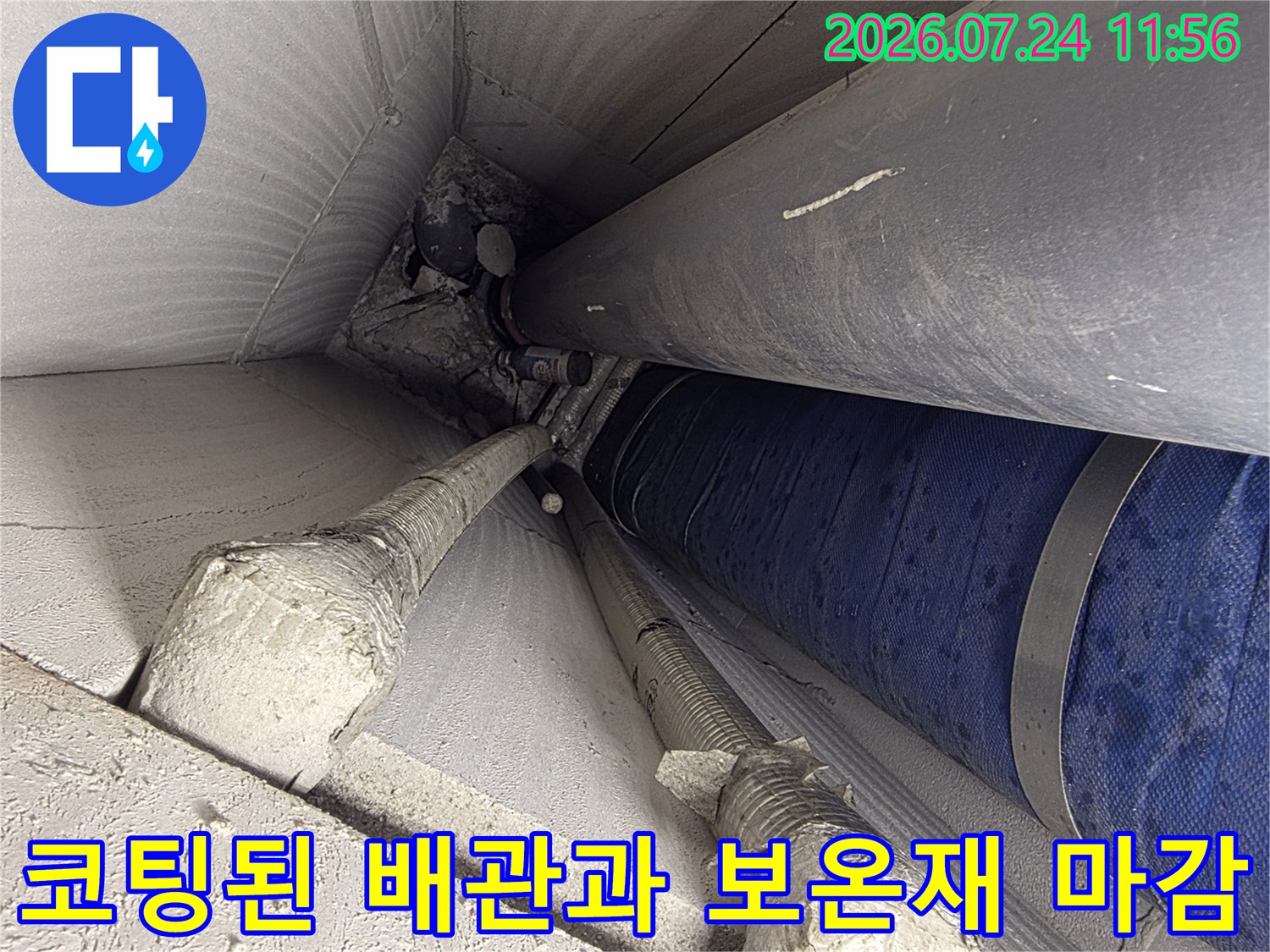 파란색 외장재로 감싸진 배관과 흰색 보온재가 겹쳐진 시공 현장