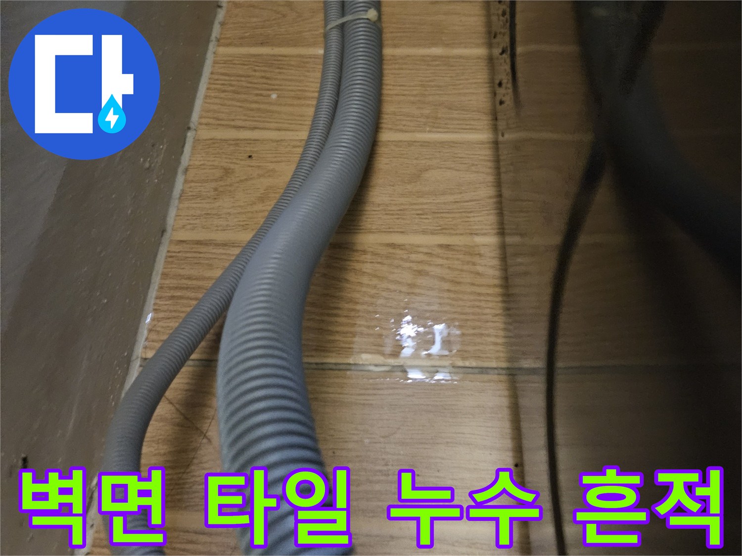 젖어있는-타일-벽면과-주름진-배수-호스
