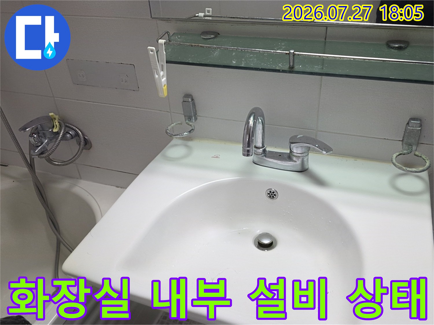 욕실 내 세면대-거울 수납장-샤워기가 설치된 전경 사진