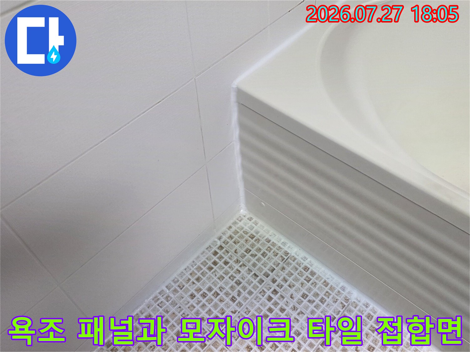 욕조 하단 플라스틱 패널과 바닥의 흰색 작은 타일-접근 부위 상세 사진