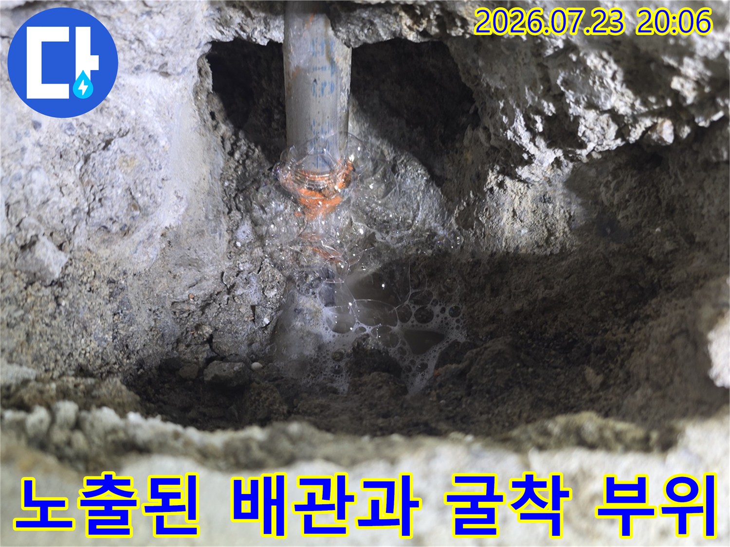 거친 콘크리트 벽면을 뚫고 나온 회색 배관 파손 부위 확인