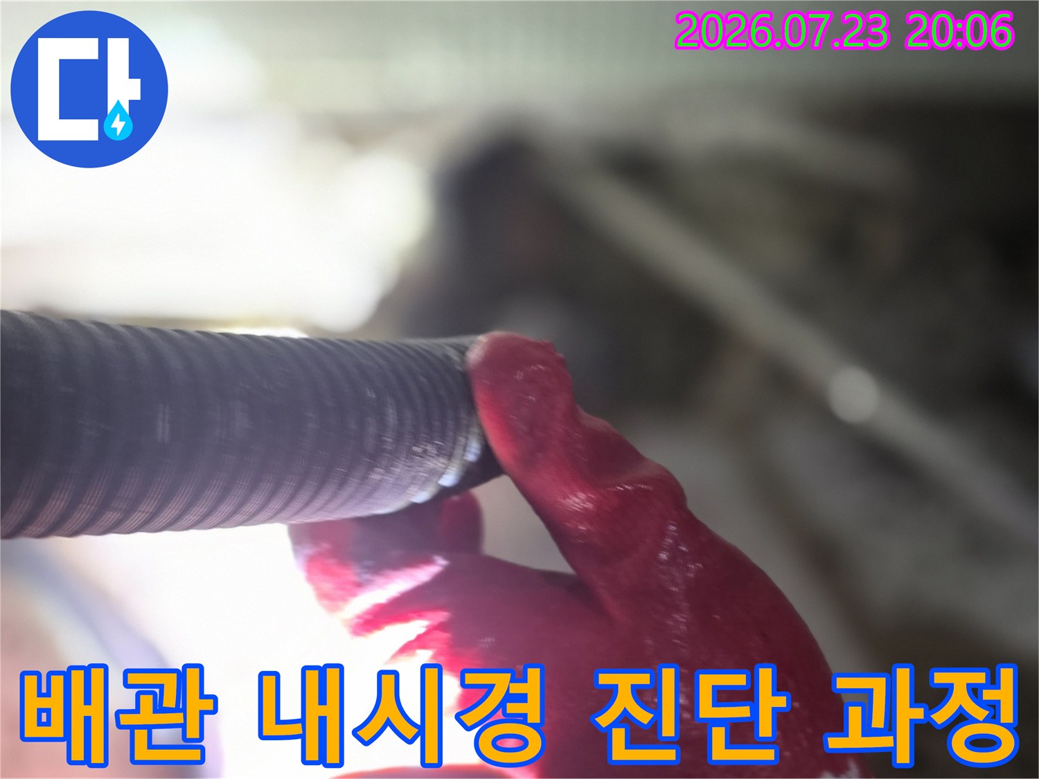 작업자가 배관에 내시경 카메라를 연결하여 내부 상태를 실시간으로 확인하는 모습