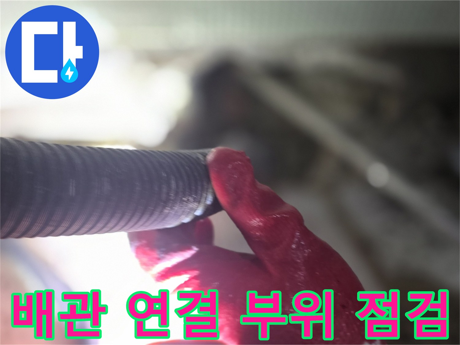 작업자가 배관의 접합 부분을 손으로 만져가며 검사하고 있습니다.