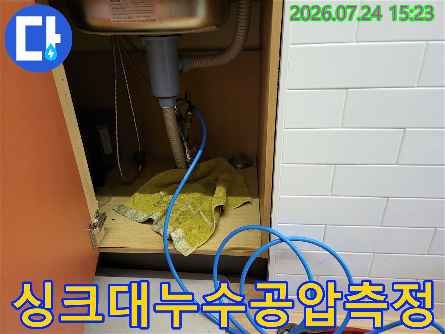 파란색-호스가-연결된-싱크대-하부-배관과-주변-환경-사진