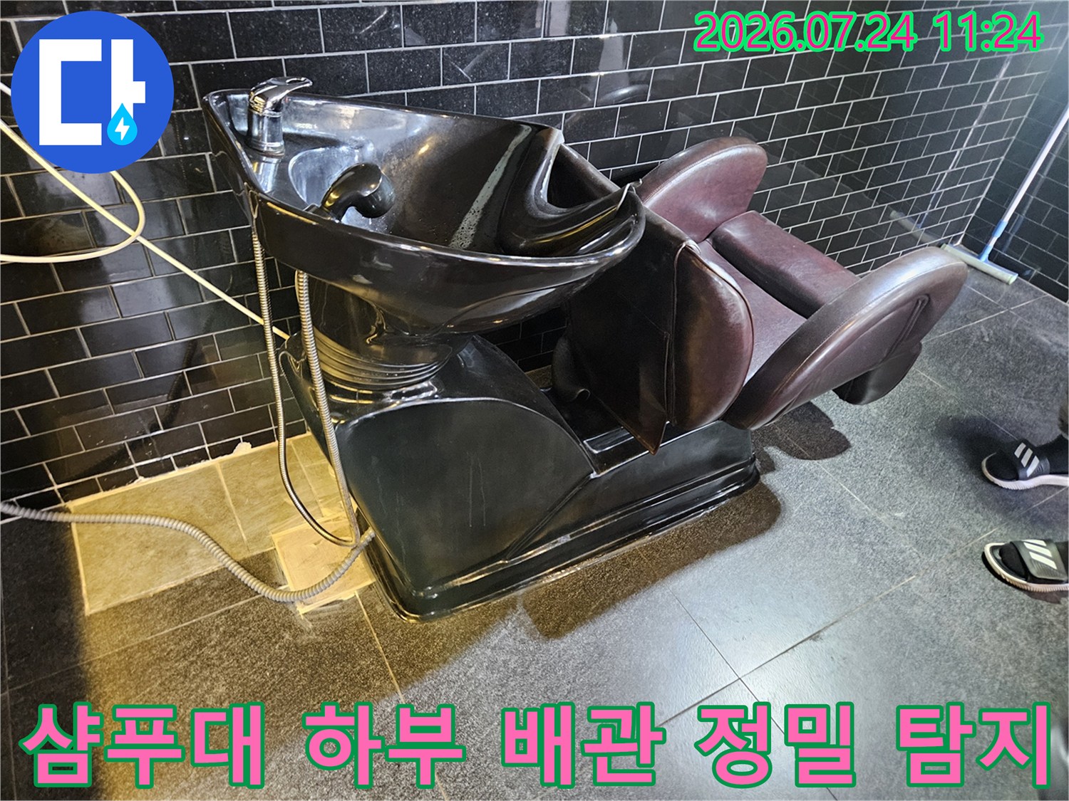 누수 지점을 추적하기 위해 샴푸대 아래 배관에 장비를 연결한 모습