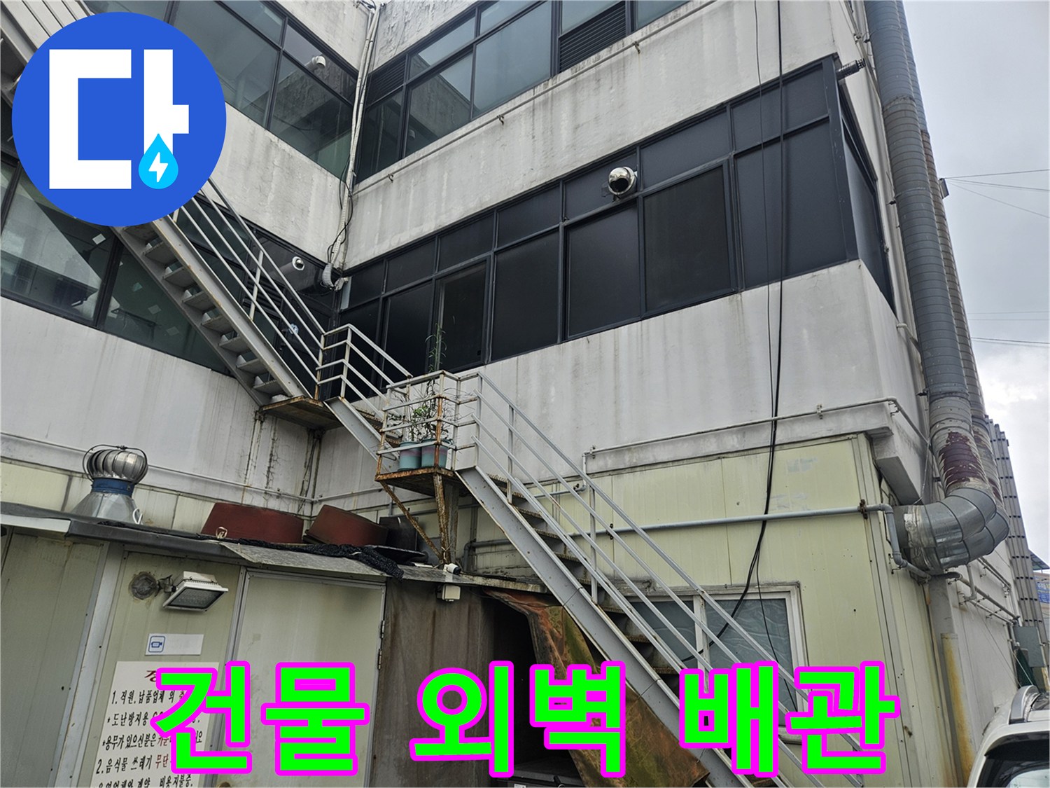 상가 건물의 외벽 구조물과 연결된 금속 배관의 모습