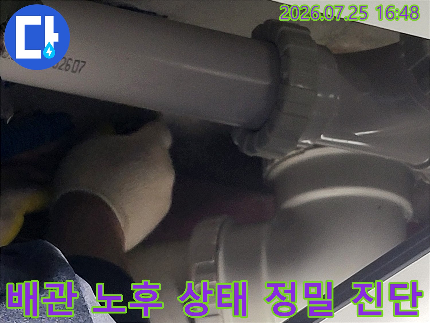 오수 배관의 굴곡과 연결 부위를 장갑을 낀 손으로 세심하게 확인하는 과정