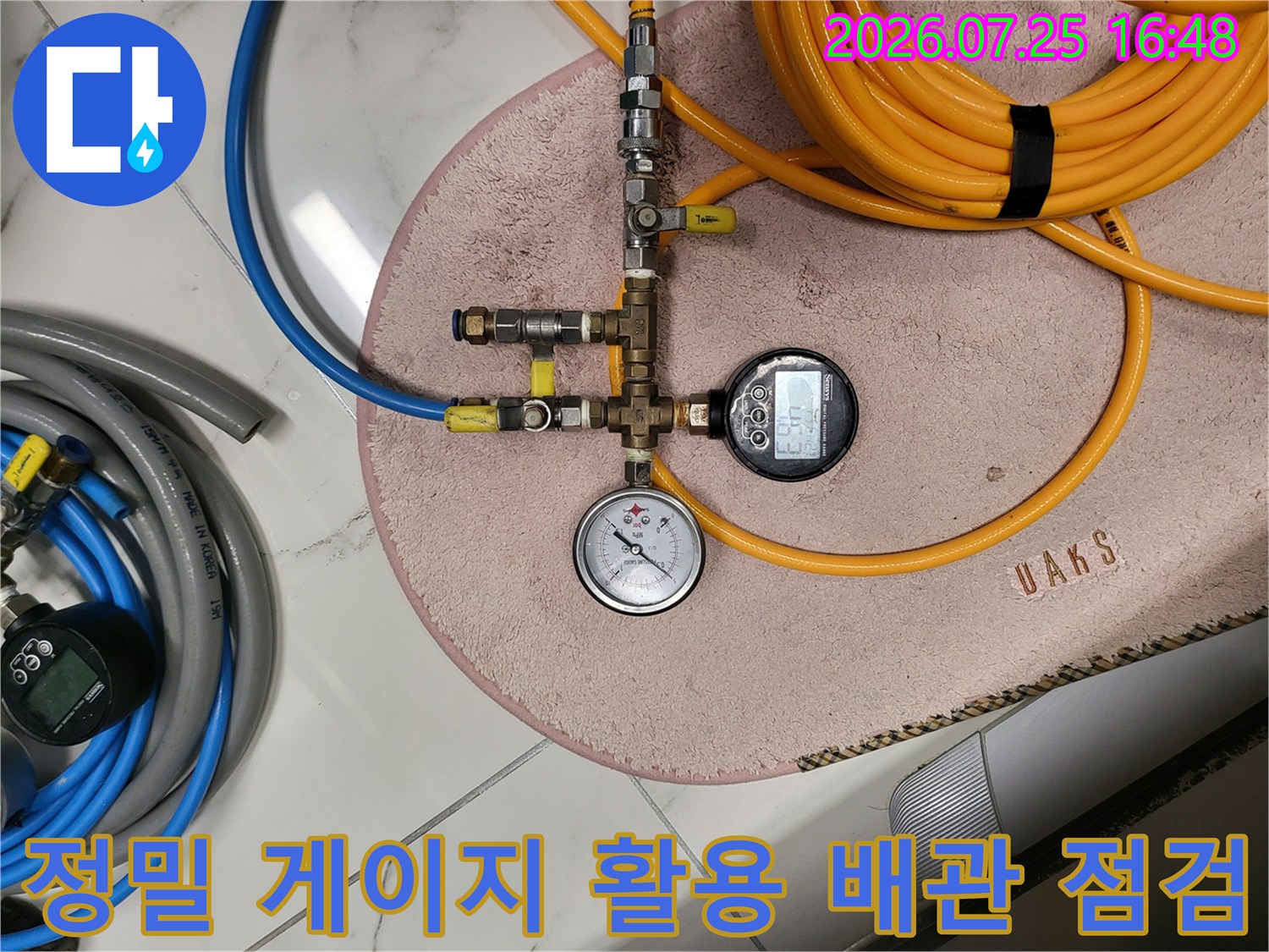 전문가용 압력계와 호스를 연결하여 상수도 계통을 정밀 점검하는 모습