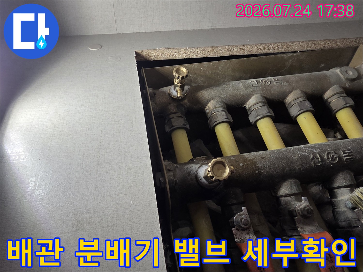분배기에 설치된 여러 개의 배관과 퇴수 밸브를 촬영한 사진