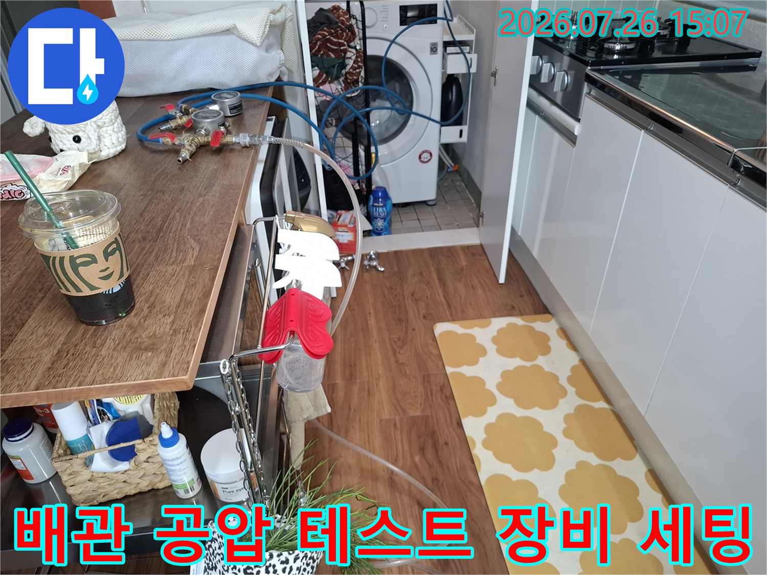 주방 조리대 옆에 배치된 누수 탐지용 압력 게이지와 연결 호스-누수 검사 단계