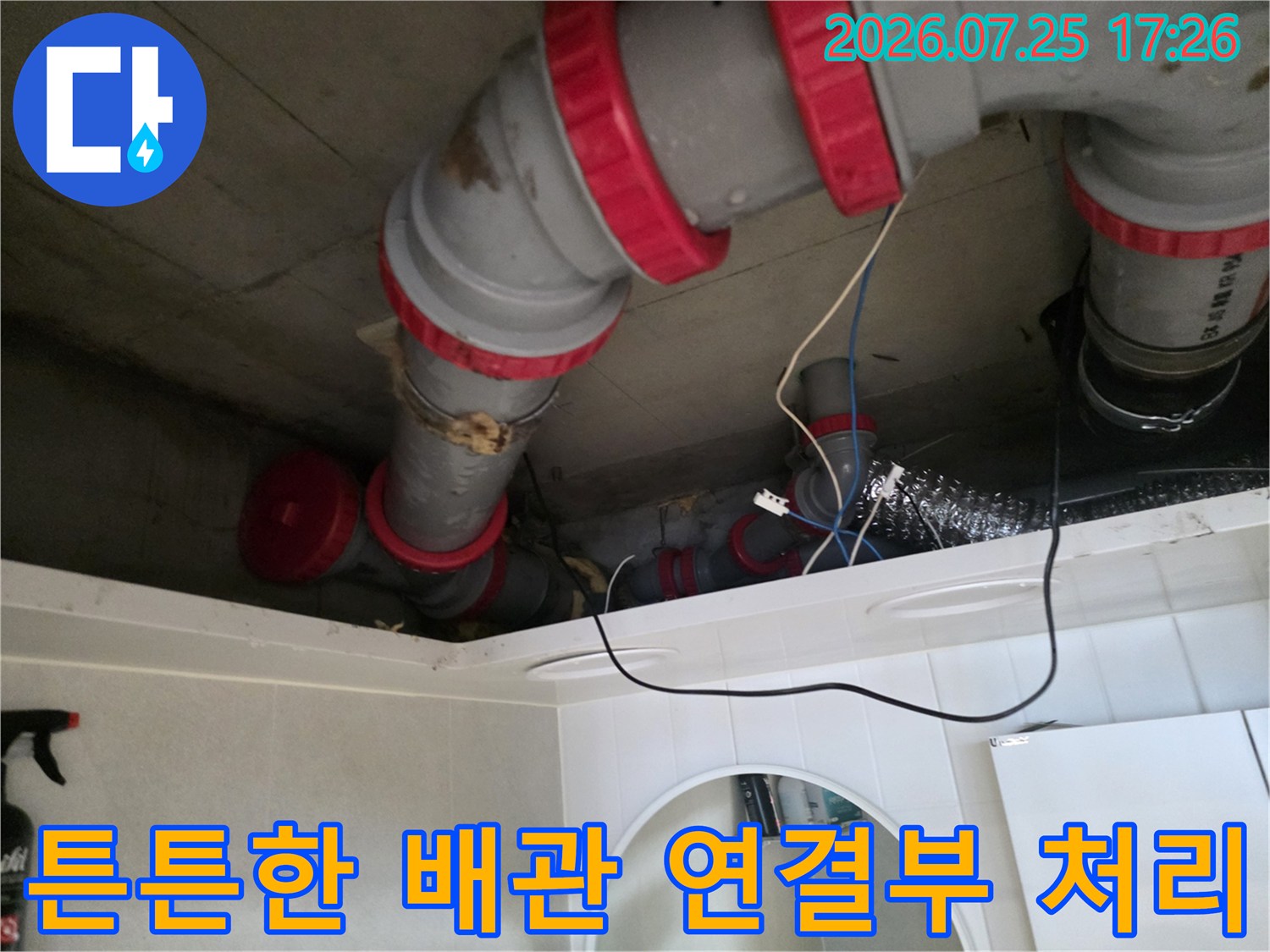 붉은색 밴드로 견고하게 고정된 천장 내부의 수도 배관 시스템