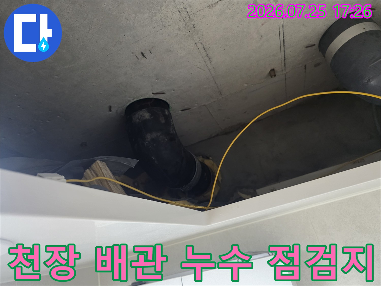 콘크리트 천장 내부에 설치된 검은색 배관과 노란색 보호재의 모습