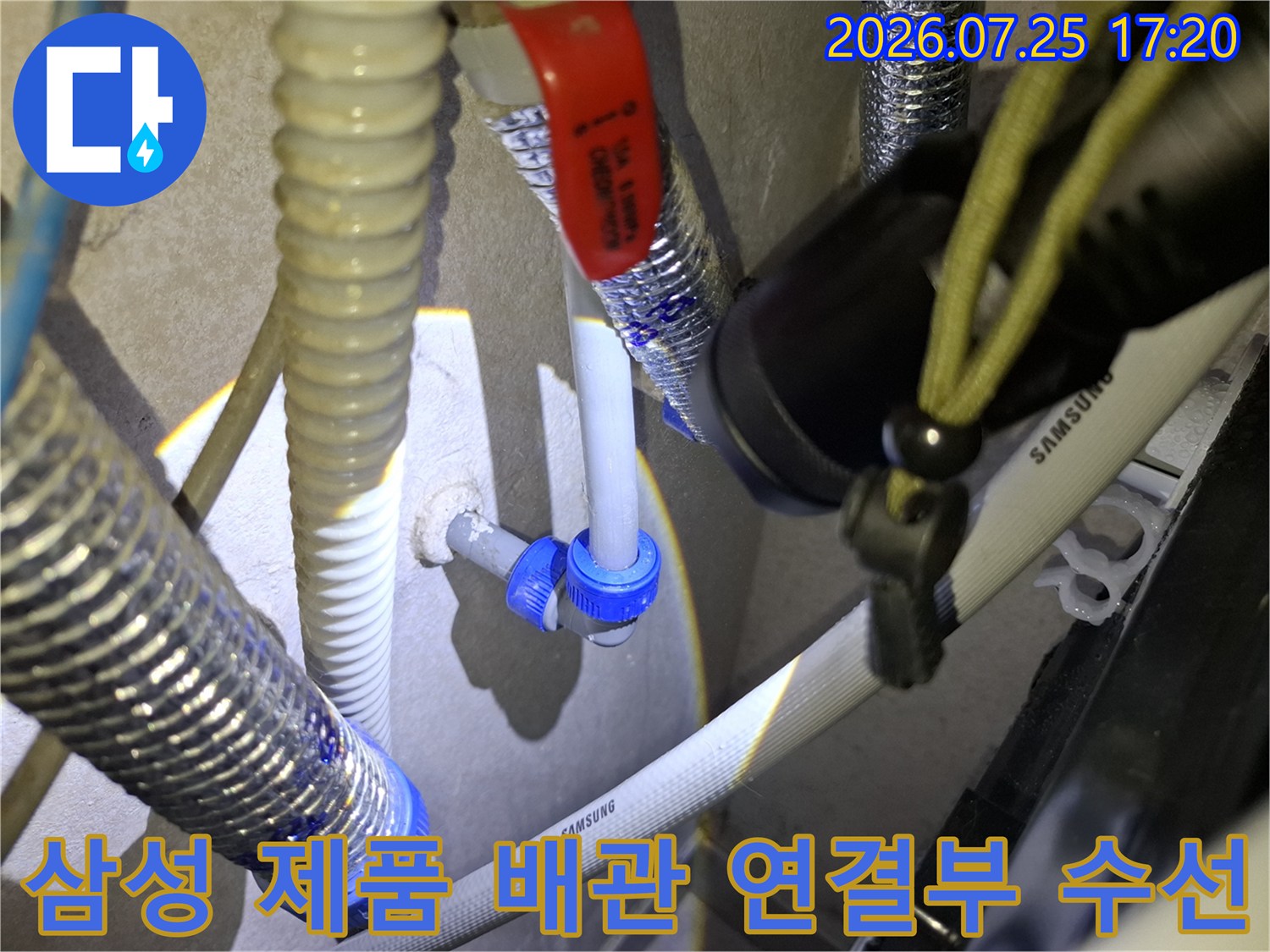 파란색 커넥터와 회색 배관이 연결된 부분에 누수 점검을 진행하는 모습