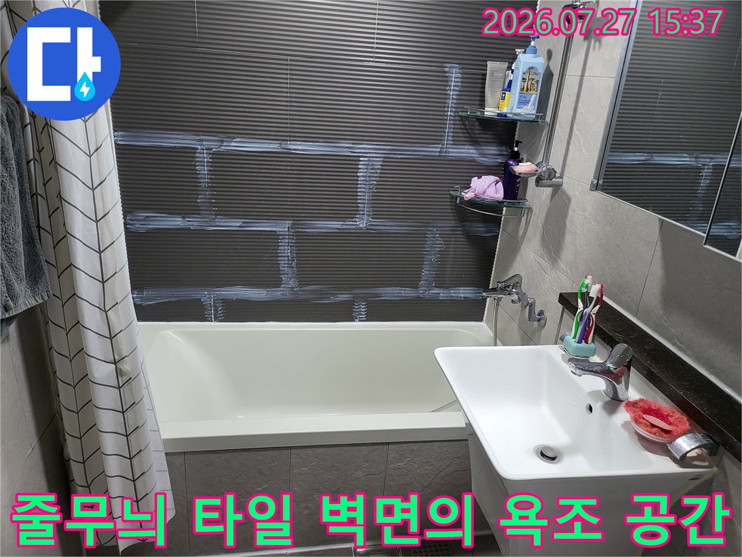 짙은 회색 줄무늬 타일이 붙어있는 화장실-우측에 세면대와 선반이 배치된 구조