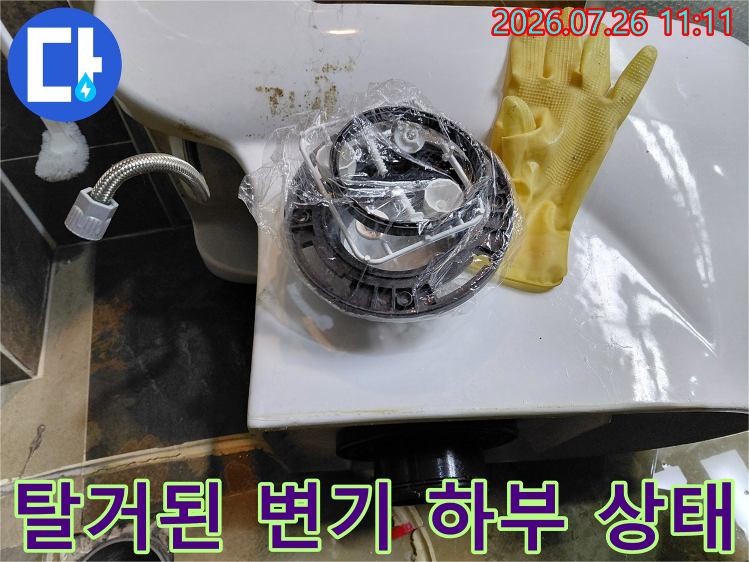 변기를 탈거하여 노출된 배수관과 주변 부품들의 점검 과정