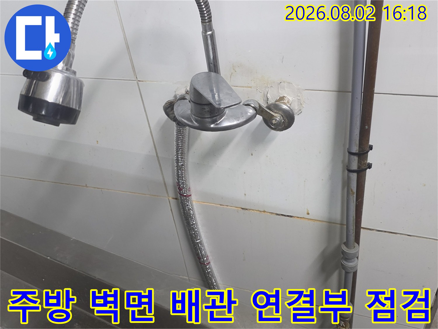상업용 주방 싱크대 하단 벽면 타일과 배관 연결 부위 점검 모습