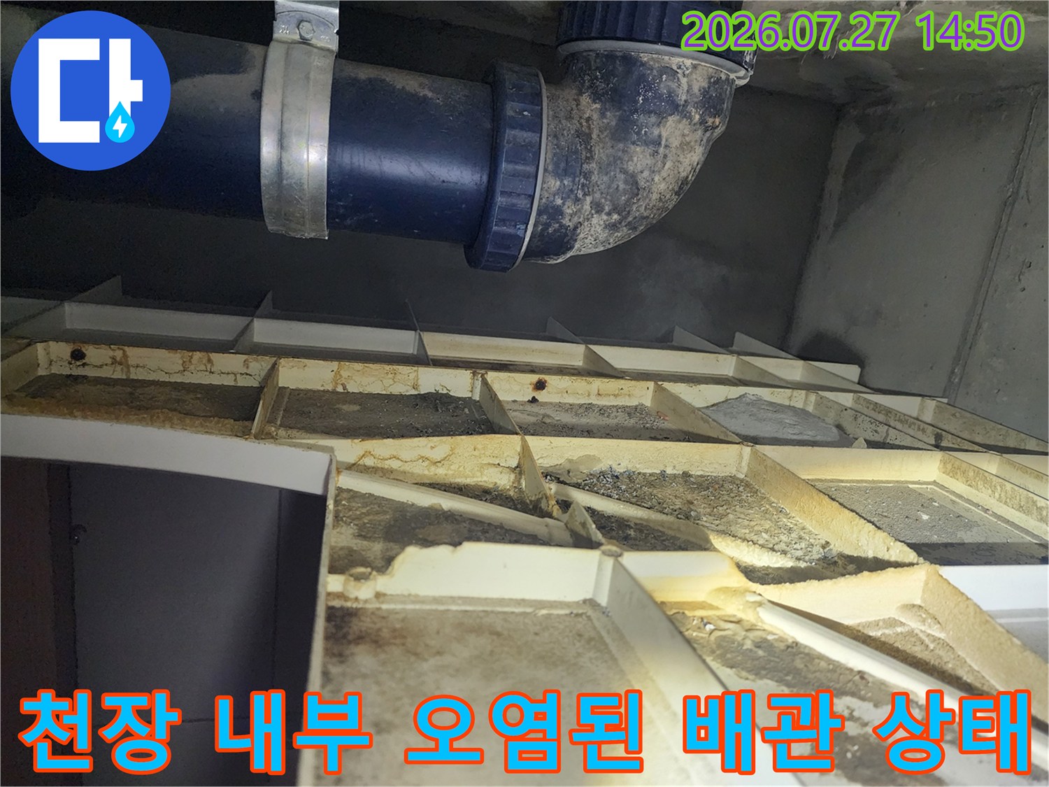 천장 마감재를 열고 확인한-오염된 파란색 하수 배관과 얼룩진 천장 구조물