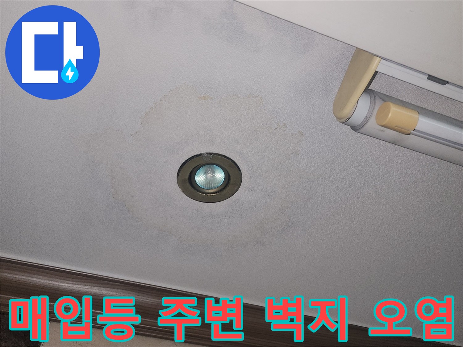 천장 조명 주변에 번진 누수 흔적과 변색된 도배지
