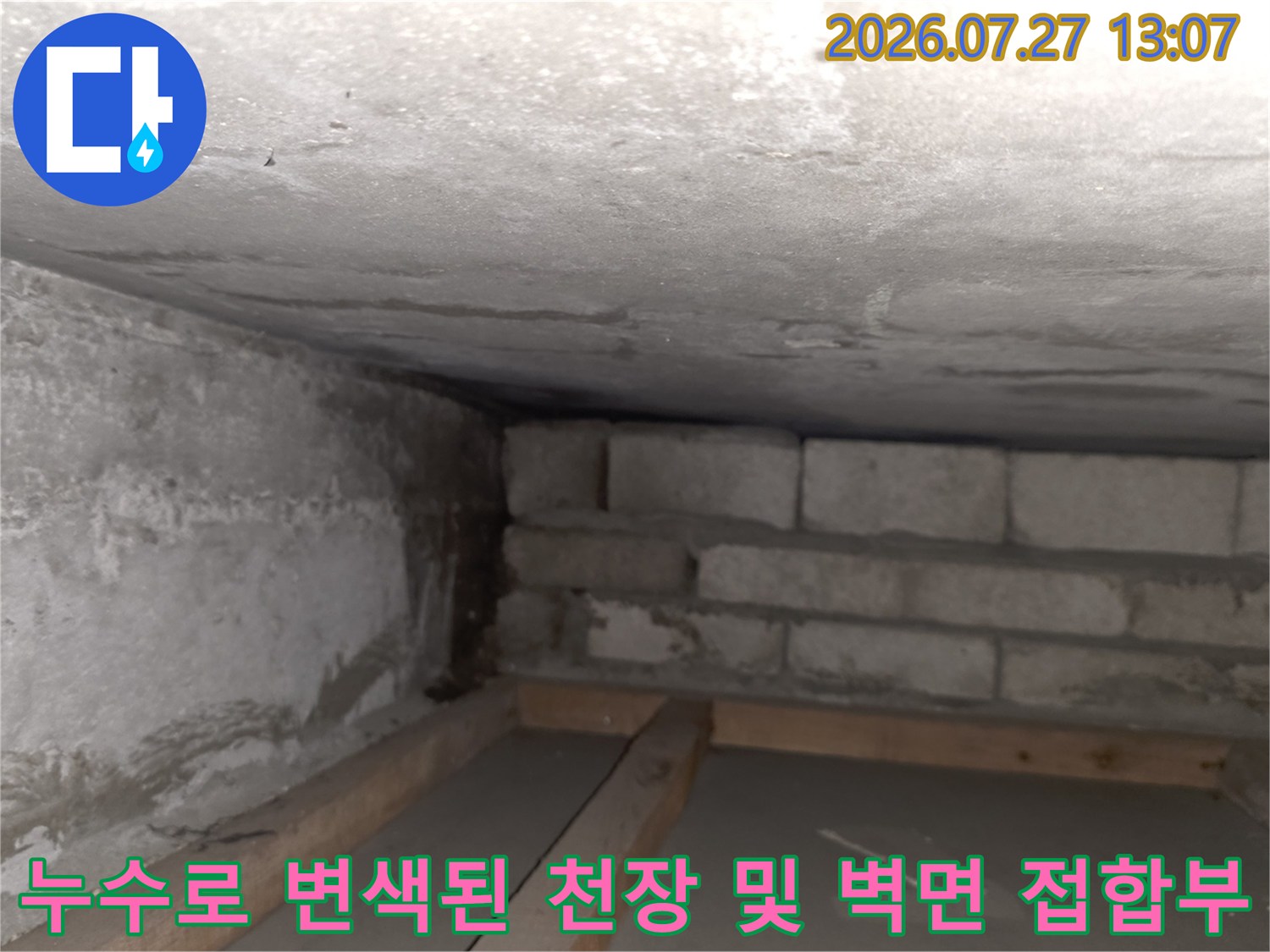 천장의 콘크리트 면과 블록 벽체가 만나는 지점에 발생한 누수 자국과 습기