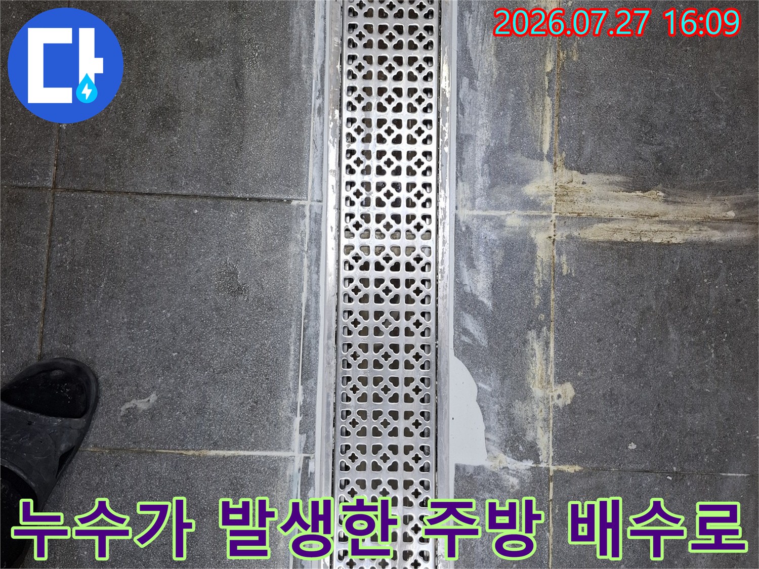 격자 모양의 스테인리스 트랜치 덮개와 그 주변의 지저분한 타일 메지 상태-누수 의심 구역