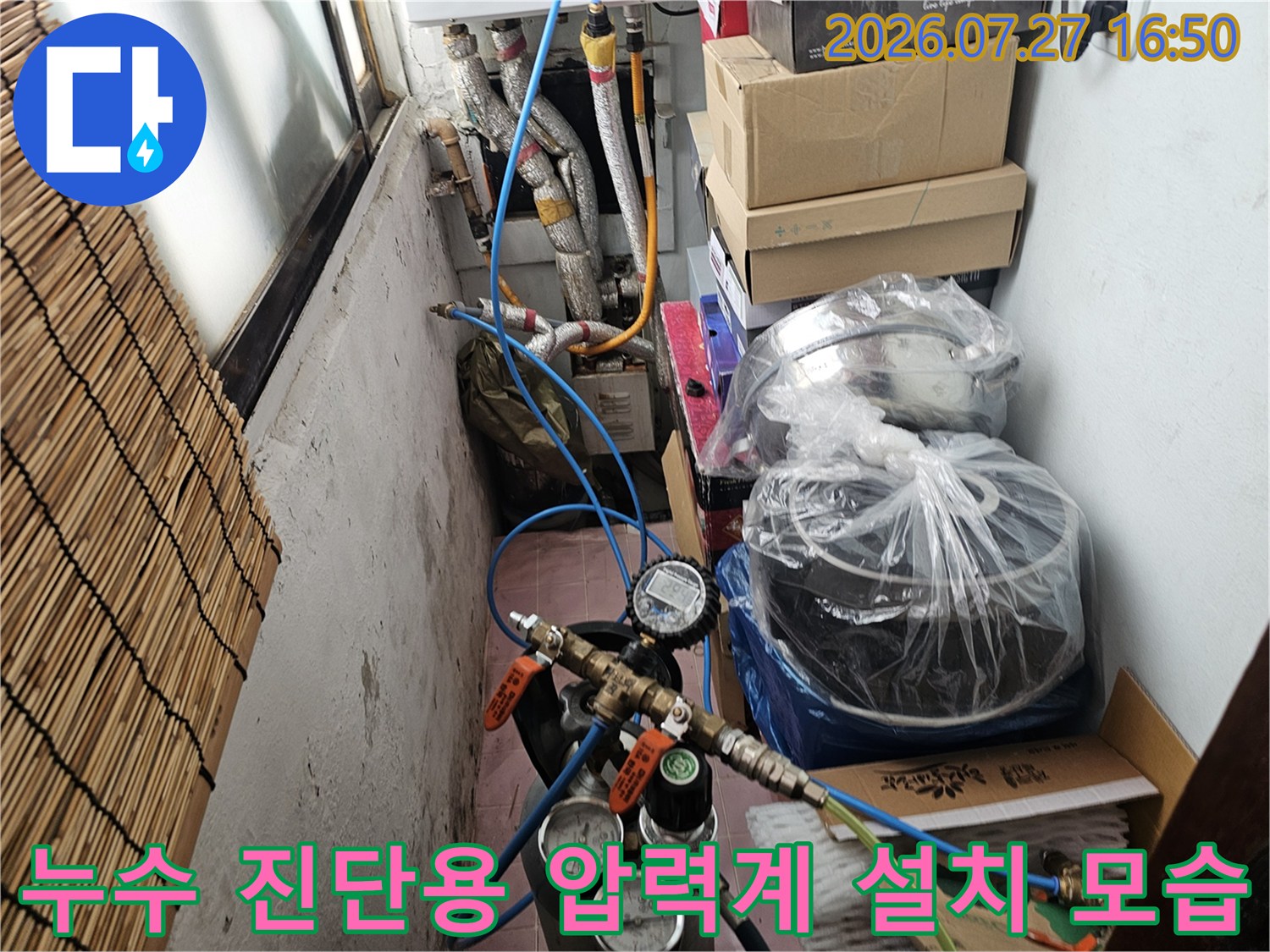 압력 게이지와 파란색 연결 호스가 복잡하게 얽힌 누수 탐지 장비 사진