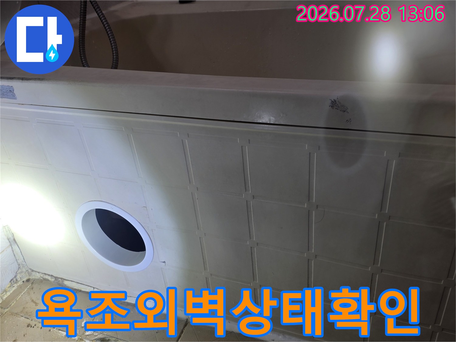 욕조 측면부 노출 부위의 배관과 주변 마감재 상태를 점검하는 장면