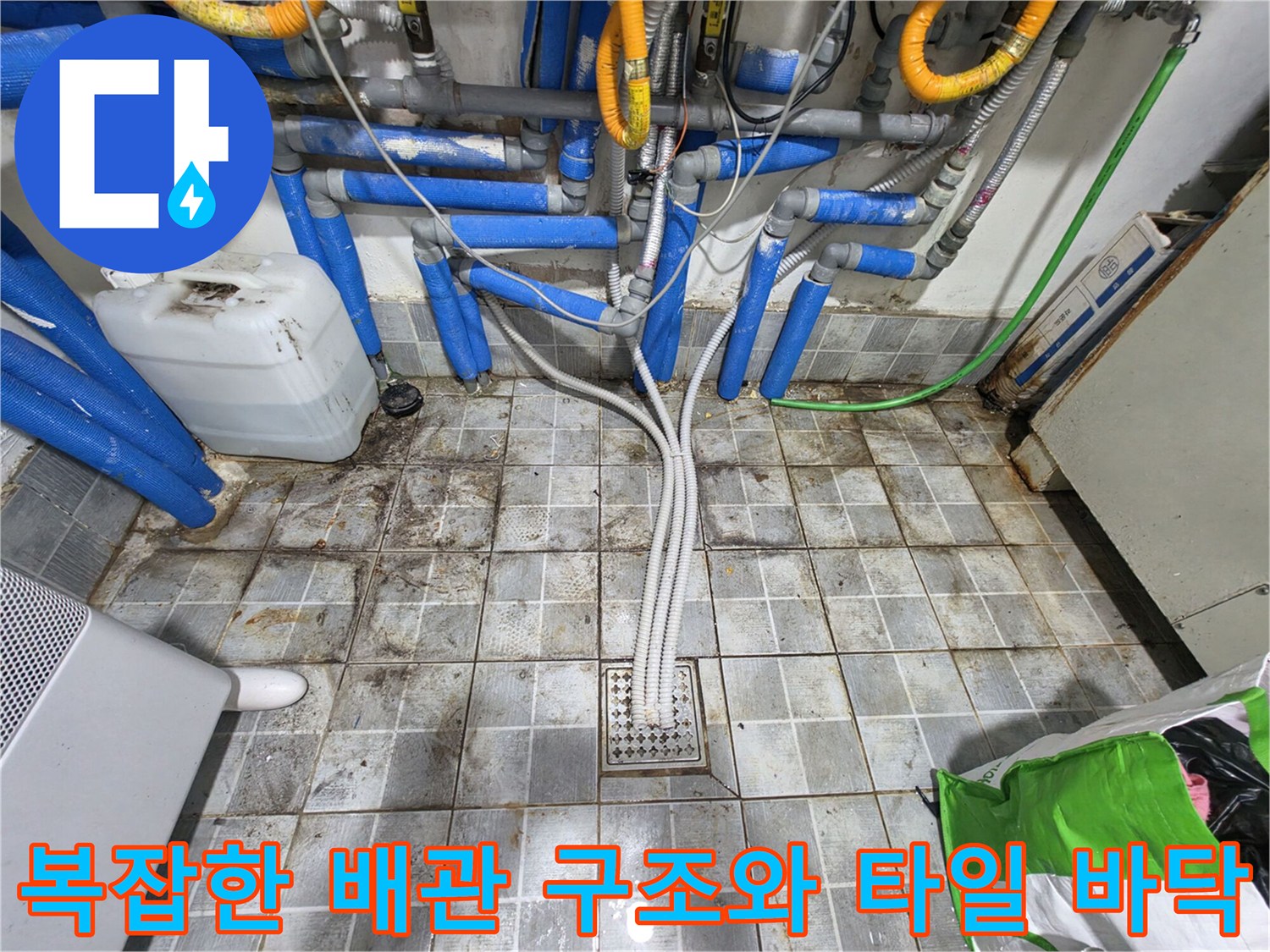 송파구 고시원 현장의 복잡하게 얽힌 파란색 및 회색 배관과 타일 바닥 모습