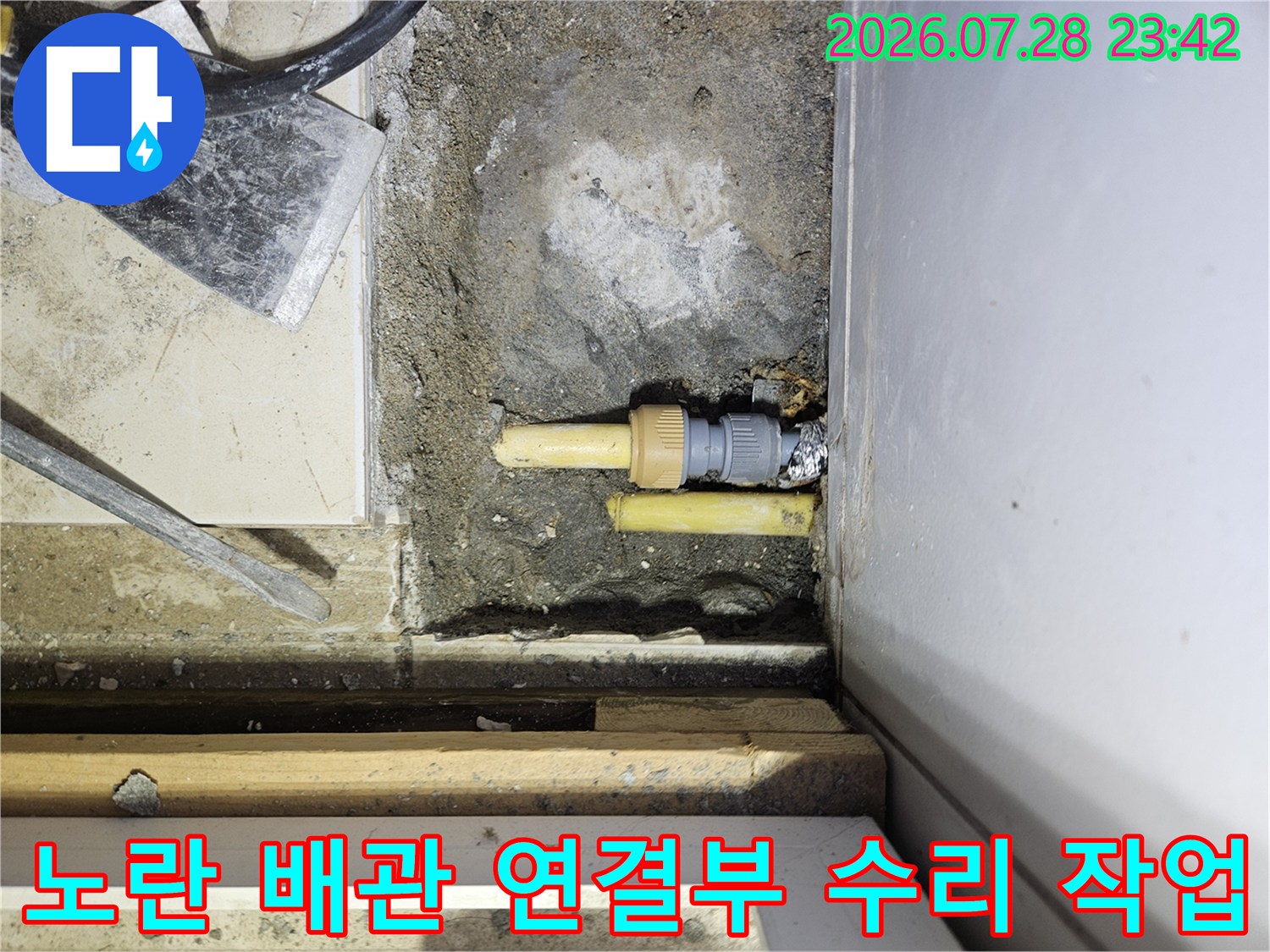 파손된 노란색 배관 부위를 절개하고 새 부속으로 교체하는 공사 현장