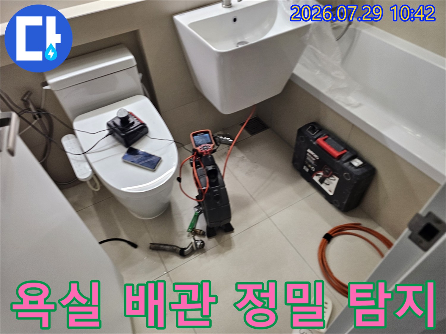 욕실 세면대 하부에서 전문 장비를 사용하여 배관 누수 지점을 정밀하게 점검하는 모습