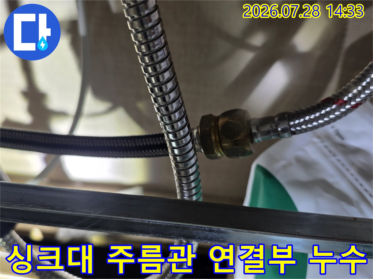 싱크대 하부의 스테인리스 주름관과 연결 너트 부위에서 물이 비치는 모습-누수 지점 확인 사진