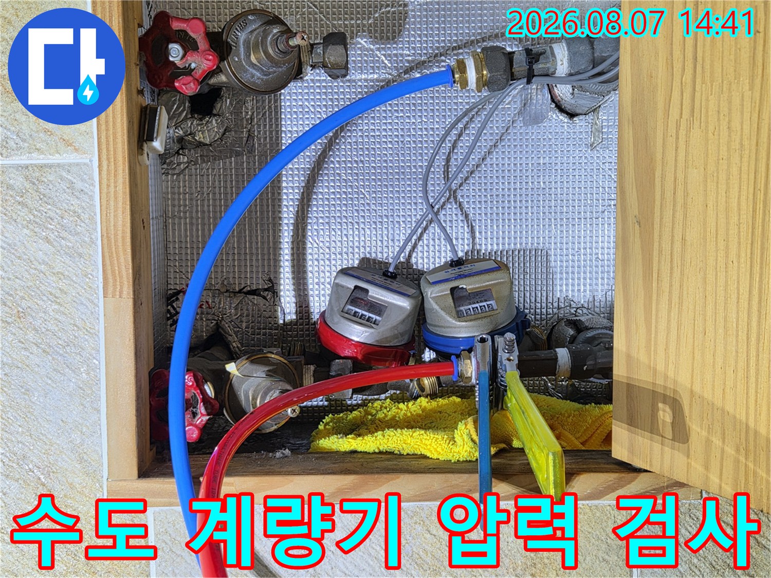 수도 계량기에 연결된 파란색과 빨간색 배관 테스트 장비