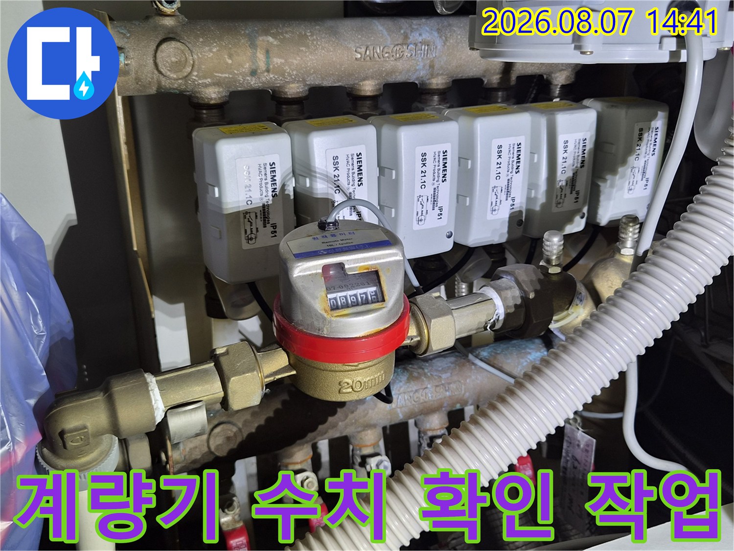 수도 계량기의 숫자판과 연결된 금속 배관의 모습입니다