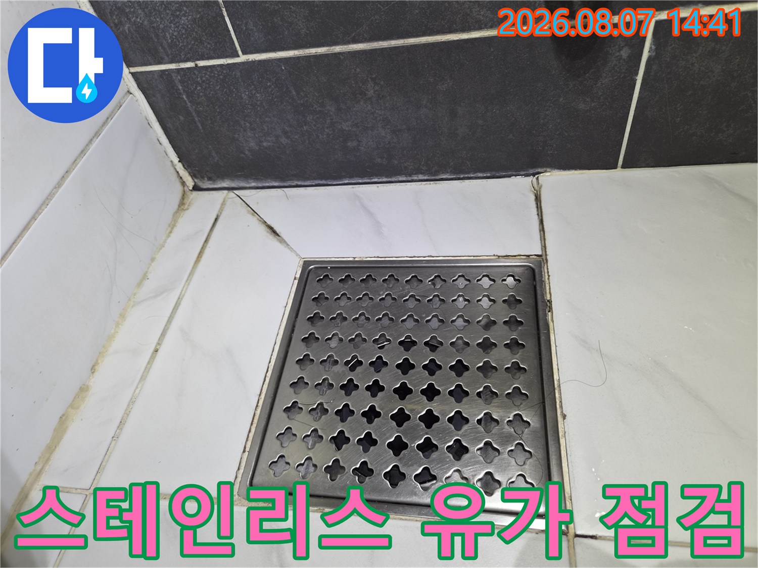 스테인리스 재질의 욕실 배수구 덮개와 타일 접합부