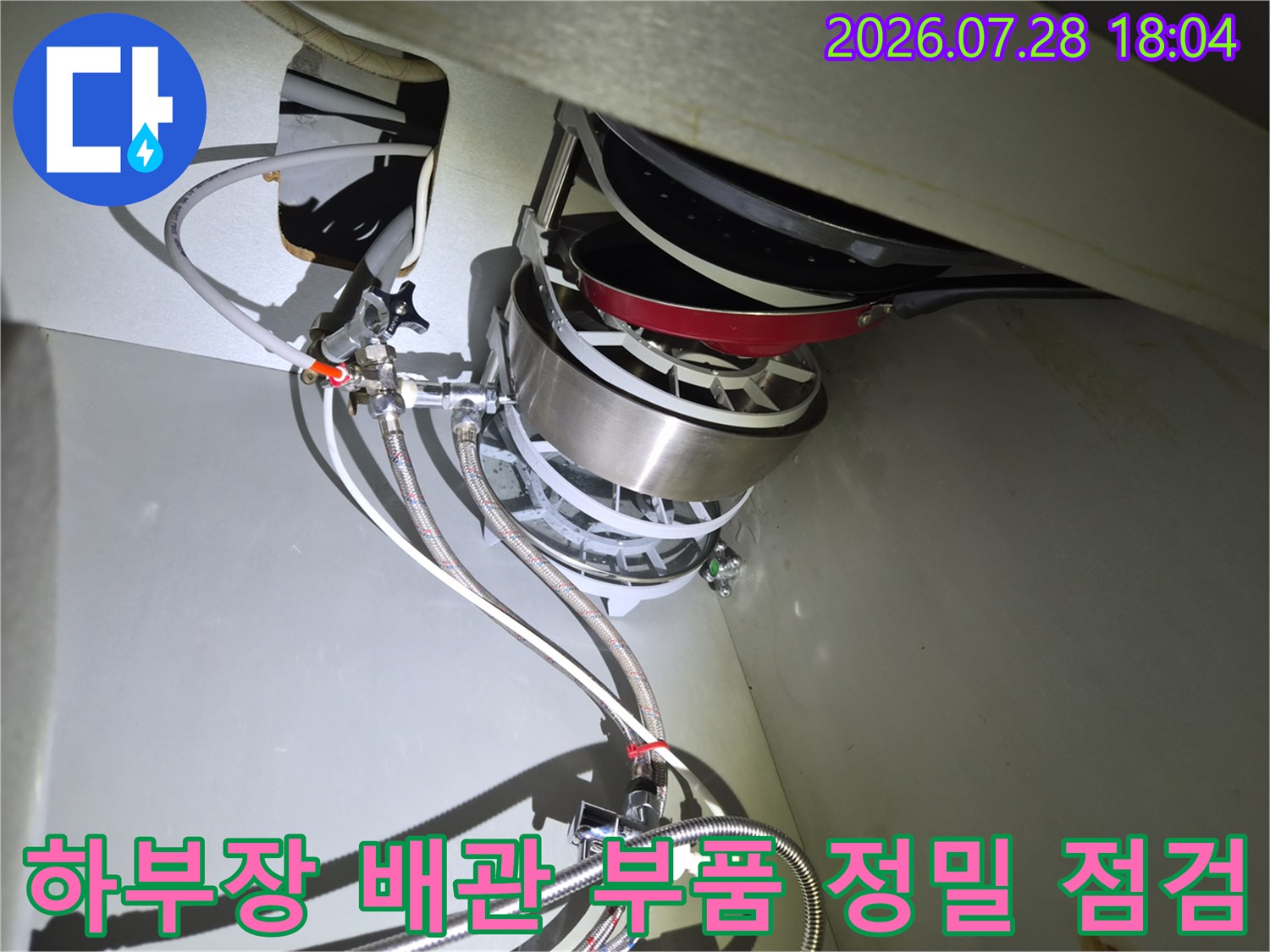 싱크대 밑 배관 연결 부위의 체결 상태를 꼼꼼하게 확인하는 기술자의 시선으로 본 사진