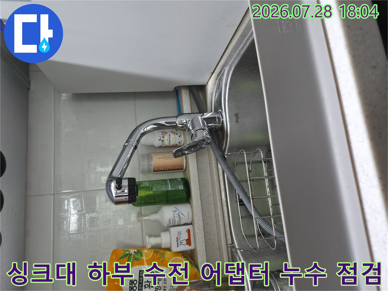 싱크대 아래 설치된 수전과 식기세척기 연결용 배관의 결합 상태를 확인하는 사진