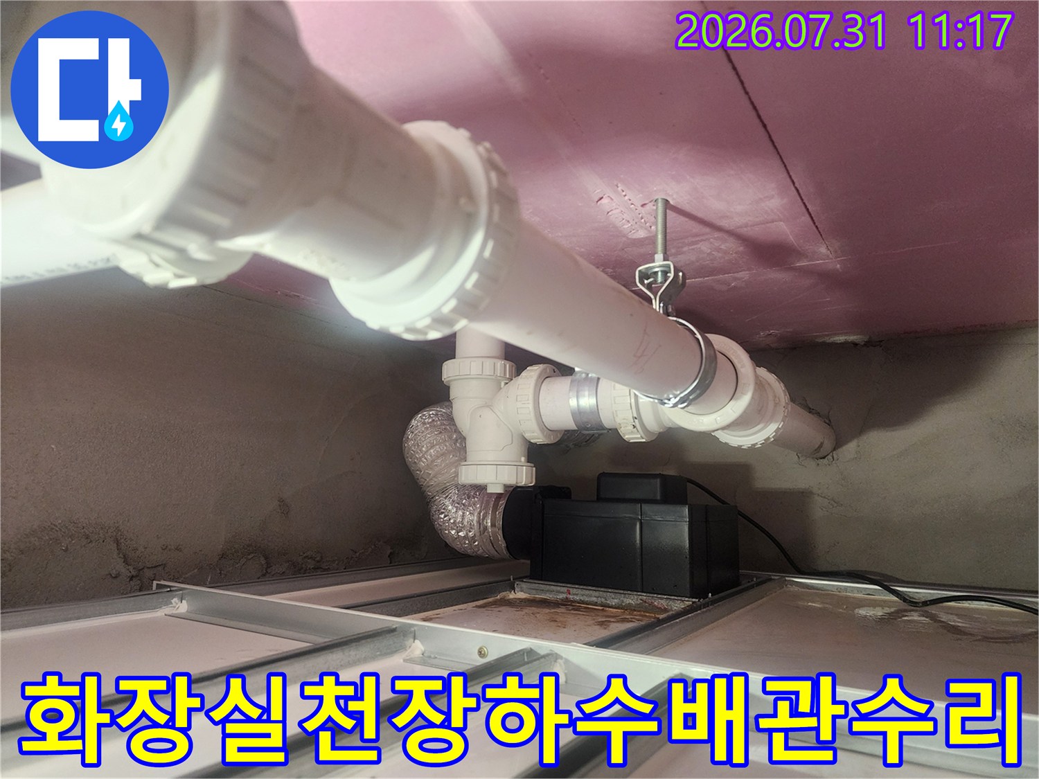 화장실 천장 내부의 노출된 배관 연결 부위와 수선 작업 현장
